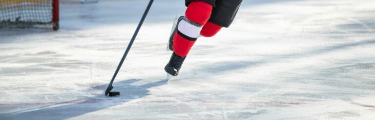 Hockey player skating with stick and puck.